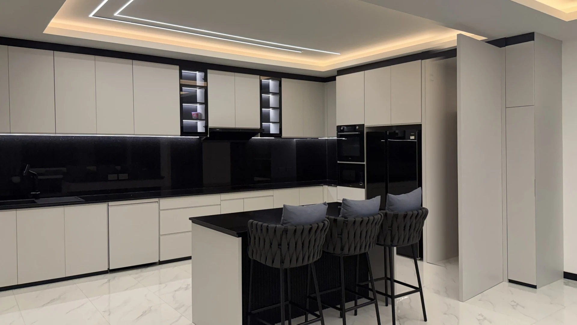 The same view at night with the hidden door open next to the fridge