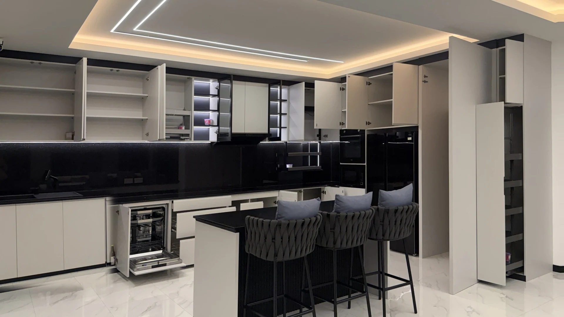 The same view at night with the wall cabinets, pull-out larder, drawers and dishwasher open