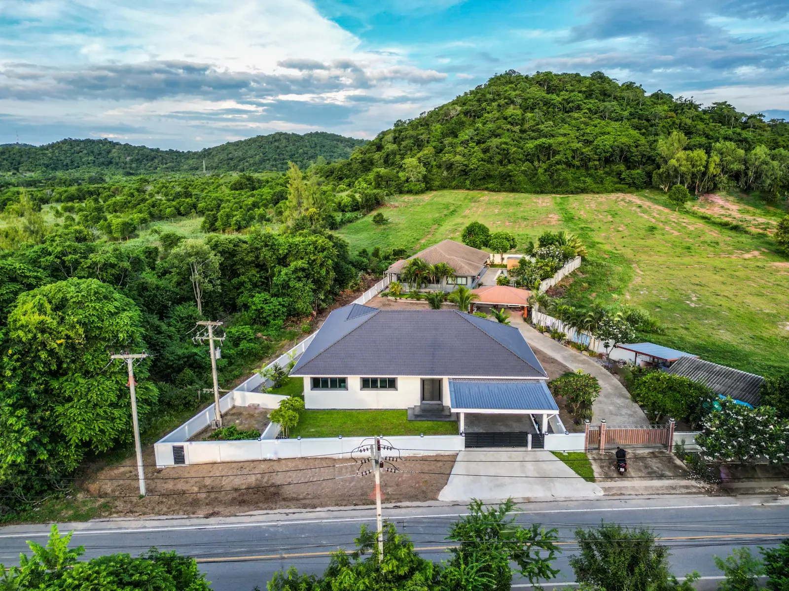 Drone view of the villa from the road with the mountain behind